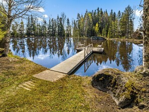 Eine Holzsteg, der sich in einen ruhigen See erstreckt, umgeben von Bäumen.