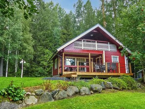 A red cabin with a balcony, surrounded by a forest. - Vacation home Pinea by Interhome (Forssa)