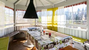 Una habitación acogedora con un banco de madera, una mesa con mantel estampado y una lámpara colgante.