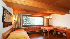 Acogedora habitación tipo cabaña con una cama, una mesa de comedor y un banco.