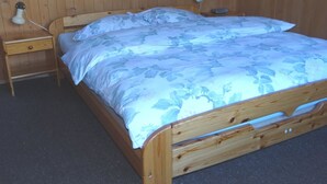 A wooden bed with a floral bedspread and two bedside lamps.