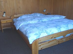 A wooden bed with a floral bedspread and two bedside lamps. - Valentine Appartement/Fewo 4-Bettwohnung by Interhome (Engelberg)