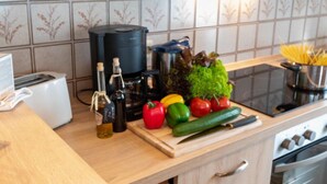 A kitchen with a toaster, coffee maker, and a variety of fresh vegetables on the counter. - Am Koper Sand by Interhome (Norddeich)