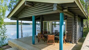 Relax on the covered deck with comfortable seating and enjoy the serene lakeside views.