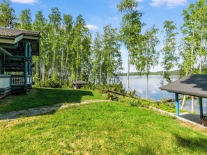 Une propriété au bord du lac, dotée d’un belvédère, d’une terrasse en bois et d’un bâtiment dont le toit est recouvert de tuiles.