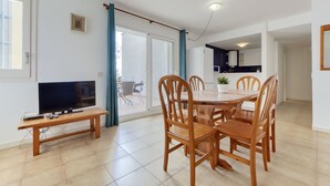A modern apartment with a dining area, a TV, and a kitchen. - Platja de Roses by Interhome (Roses)