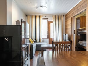 A compact living space with a kitchenette, a sofa, a dining table, and a wooden wardrobe. - Villa ylläs 201 by Interhome (Ylläsjärvi)