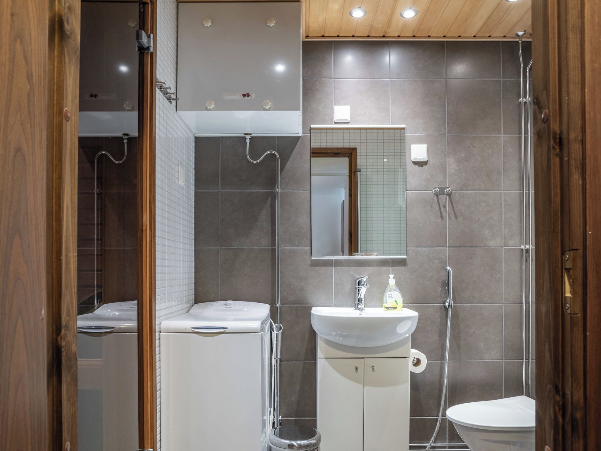 A modern bathroom with a shower, toilet, and sink.