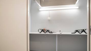 Une pièce avec une porte blanche, un mur blanc et un luminaire fixé au plafond.