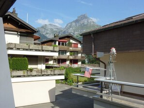 Ein Wohngebiet mit mehrstöckigen Gebäuden, einem Berg im Hintergrund und einer Flagge auf einem Tisch.