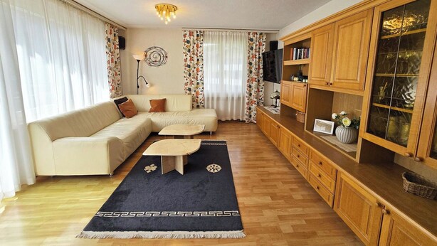 Una sala de estar con sofá, mesa de centro y armarios de madera.