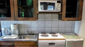 A kitchen with a microwave, stove, and refrigerator. - Grand Roc by Interhome (Argentière)