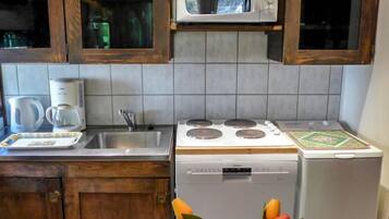 Een koelkast, een vaatwasser, kookgerei, borden en bestek