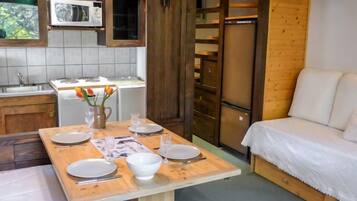 Een koelkast, een vaatwasser, kookgerei, borden en bestek