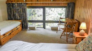 A room with a bed, a wooden desk, a chair, and a lamp. - Grand Roc by Interhome (Argentière)