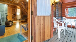 Ein Interieur einer Holzhütte mit Essbereich, einer Küche und einer Treppe.