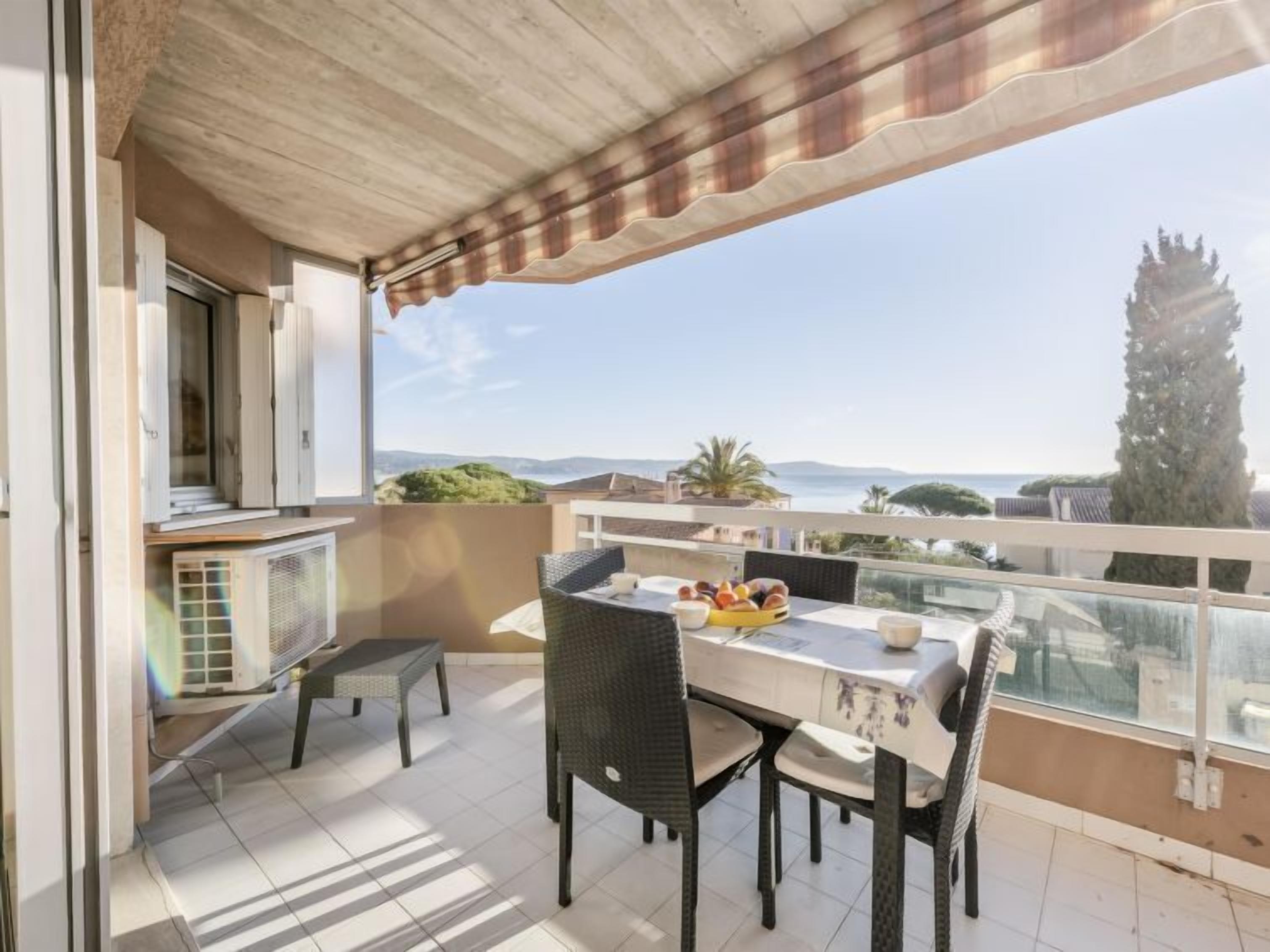 Een balkon met een eettafel, met uitzicht op een prachtig landschap.