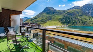 Een balkon met uitzicht op bergen en een meer.