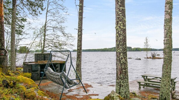 A lakeside cabin with a swing chair, a brick fireplace, and a picnic table. - Tipuniemi by Interhome (Hämeenlinna)