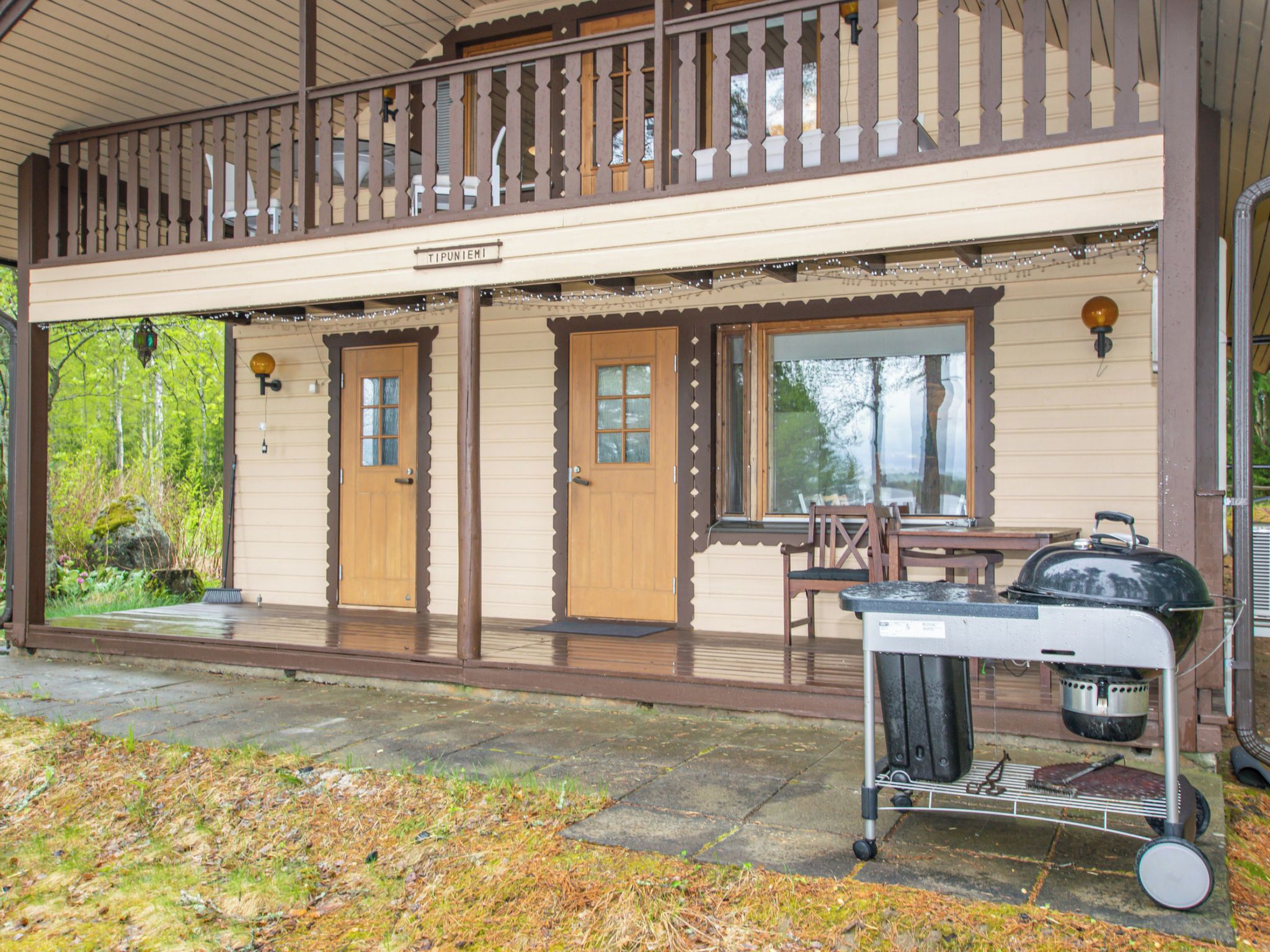 Un bâtiment à deux étages doté d’un balcon, de portes en bois et d’une grille au rez-de-chaussée.