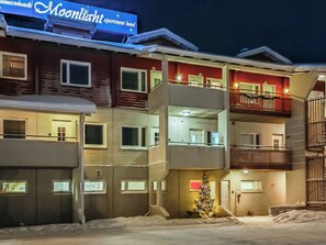 A multi-story hotel with balconies and a Christmas tree in the courtyard.