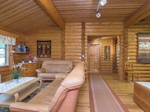 A log cabin interior with a sofa, a table, and a mirror. - Uitonniemi, rummukkala by Interhome (Heinävesi)