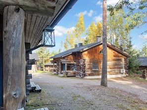 A rustic log cabin with a porch, a bench, and a clear view of the surrounding forest. - Vuokatinportti a 9 by Interhome (Sotkamo)