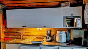 A compact kitchen with a sink, a coffee maker, a toaster, and a microwave. - Tievatupa 2, pienempi by Interhome (Ylläsjärvi)