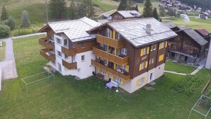 A multi-story hotel with balconies, a ski slope in the background, and a mountainous landscape. - Weideli by Interhome (Saas-Grund)