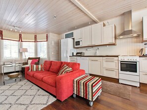 A modern kitchen with white cabinetry, a built-in microwave, and a stove. - Vuosselinhovi a by Interhome (Kuusamo)
