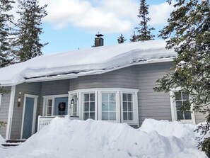 A house with a snow-covered roof and a large snowbank in front. - Vuosselinhovi a by Interhome (Kuusamo)