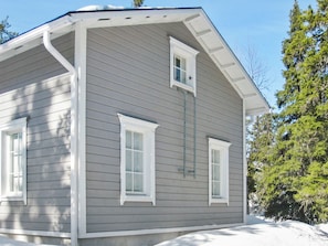 Une maison à deux étages, avec un revêtement extérieur gris, des bordures blanches et un porche avant couvert.