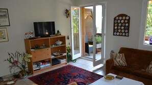 A living room with a sofa, a coffee table, a TV, and a bookshelf. - Hübeli (Arm) by Interhome (Zweisimmen)