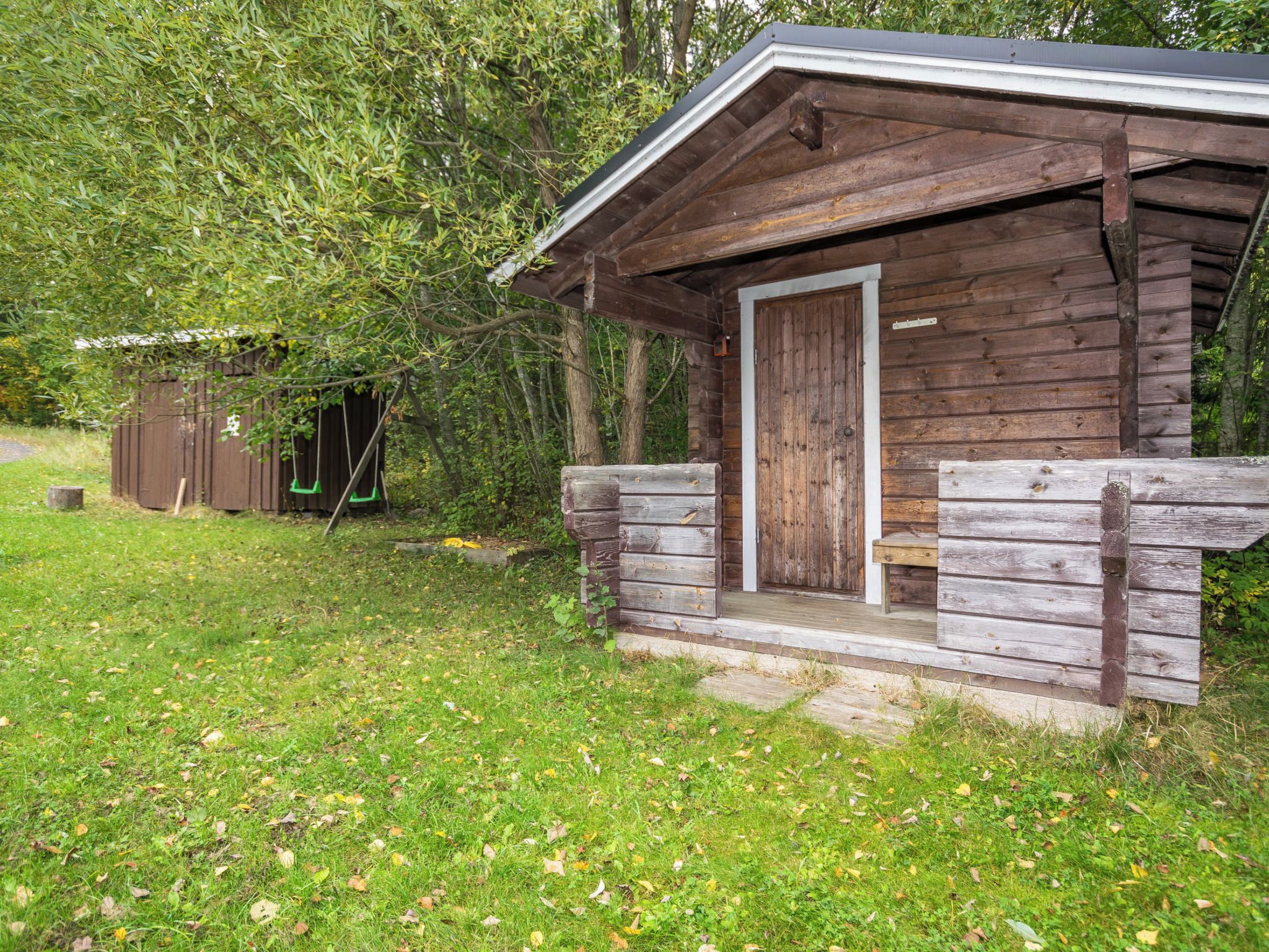 Une cabane rustique avec une porte en bois et un petit porche.