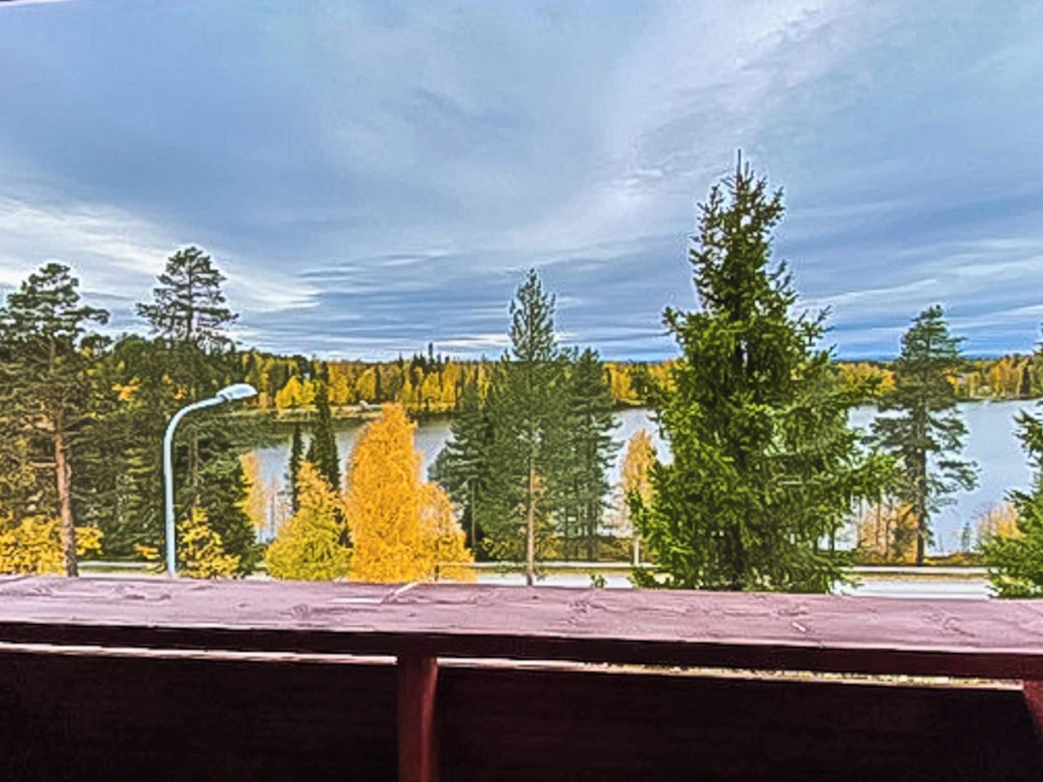 A view of a lake with trees and a clear sky.