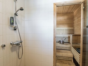 Une douche équipée d’un pommeau de douche à main et d’un robinet fixé au mur.