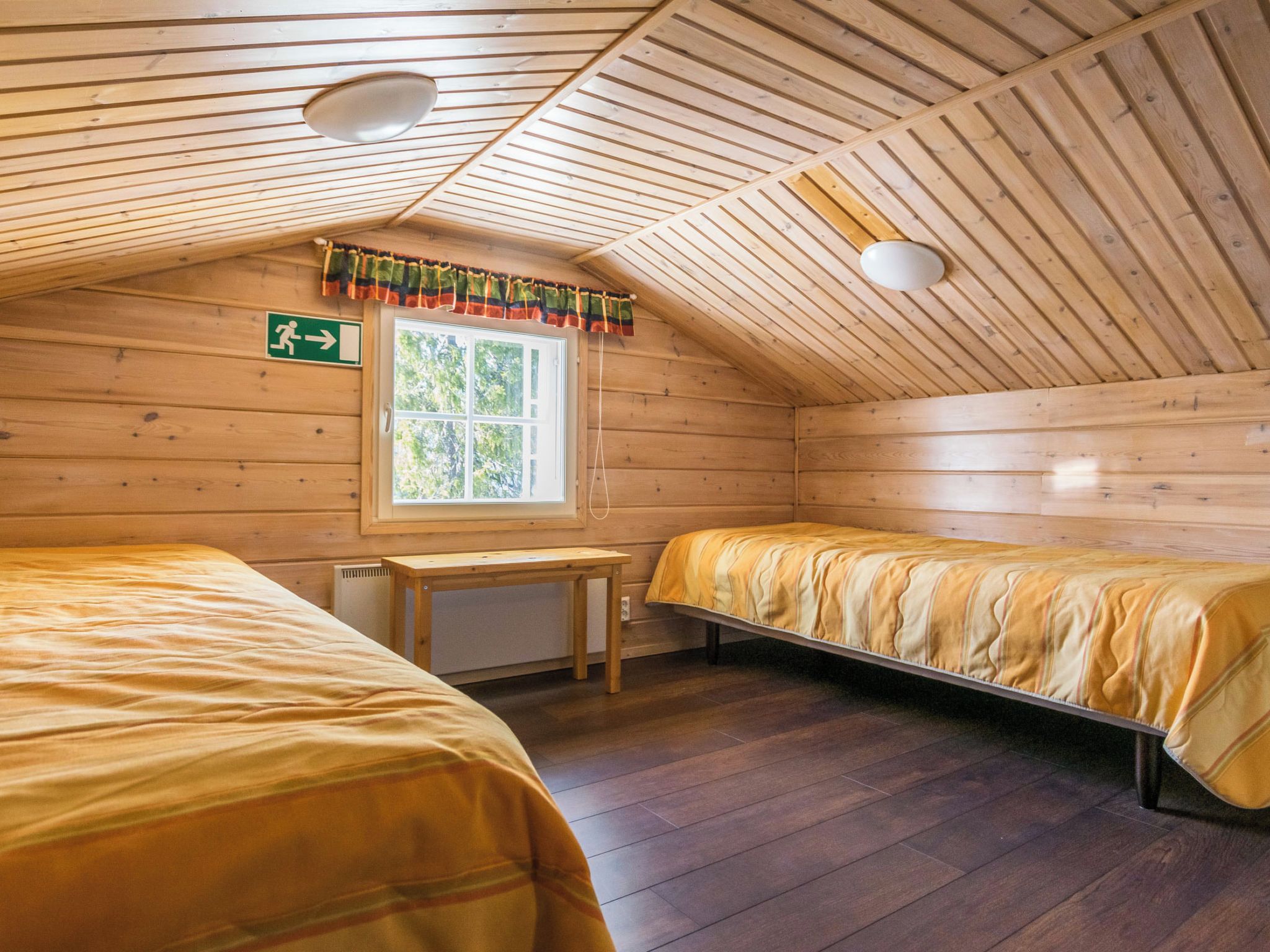 A cabin with two beds, a window, and a small table.