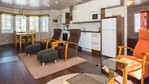 Ein modernes Interieur mit Essbereich, Küche und Sitzgelegenheiten mit Hocker und Stühlen.