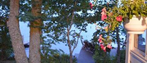 A pathway leading to a building with a hanging flower pot.