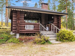 A log cabin with a porch, a chimney, and a small staircase leading to the entrance. - Rinneranta by Interhome (Mikkeli)