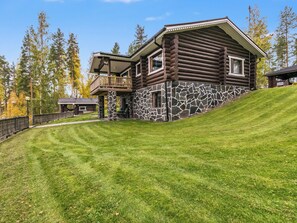 A log cabin with a stone foundation, a balcony, and a grassy yard. - Rinneranta by Interhome (Mikkeli)