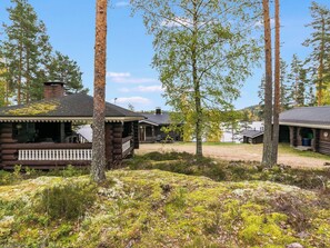 A log cabin with a porch and a small deck, surrounded by trees and a grassy area. - Rinneranta by Interhome (Mikkeli)