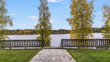 Une terrasse en bois qui mène à un lac, avec des bancs de chaque côté.