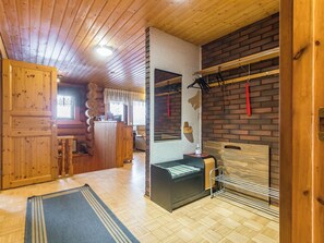 A wooden interior with a fireplace, a mirror, and a wooden door. - Rinneranta by Interhome (Mikkeli)
