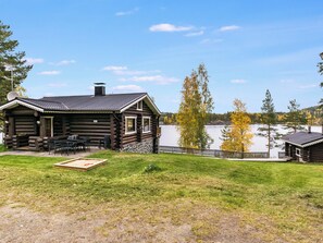 A log cabin with a deck and outdoor seating, overlooking a lake. - Rinneranta by Interhome (Mikkeli)