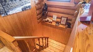 L’intérieur est en bois et un escalier mène à un niveau inférieur. On y trouve des étagères en bois où sont exposés divers objets, notamment des figurines et des tableaux encadrés.