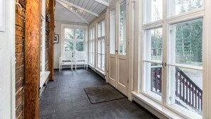 A corridor with wooden walls, large windows, and a bench. - Säikkäranta by Interhome (Oulunsalo)