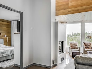 A modern interior with a bed, a TV, and a seating area with chairs.