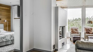 A modern interior with a bed, a TV, and a seating area with a view.