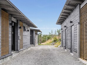 A building with a gravel driveway leading to a wooden door.